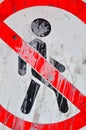 A red-and-white sign, smeared with paint, dirt, and cracks - a person is not allowed to pass.