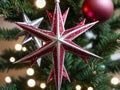 A Red And White Star Orname On A Christmas Tree. Generative AI