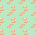 Red and white striped candy canes on a blue background. Christmas seamless pattern with candy canes Royalty Free Stock Photo