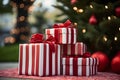 Red and white striped christmas gifts in front of christmas tree