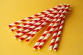 Red and white striped drinking straws on a yellow background Royalty Free Stock Photo