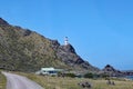 The red and white striped lighthouse at Cape Palliser on North Island, New Zealand stands high on the cliffs. The light was built Royalty Free Stock Photo