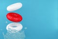 Red and white swimming rubber rings on blue background with water splashes. A splash of water. Floating lifebuoy.