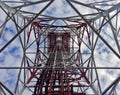 Red white telecommunication tower against blue sky and white cloud- bottom view