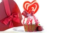 Colorful novelty cupcake decorated with candy and large heart shaped lollipop