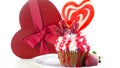 Colorful novelty cupcake decorated with candy and large heart shaped lollipop