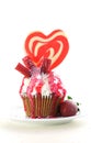 Colorful novelty cupcake decorated with candy and large heart shaped lollipop