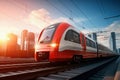 A red and white train traveling down train tracks. High-speed suburban train at sunset Royalty Free Stock Photo