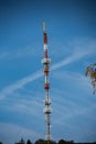 Red-white transmission mast braced with ropes Royalty Free Stock Photo