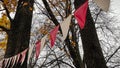 Red and white triangular bunting hanging against a background of bright yellow autumn foliage and sky Royalty Free Stock Photo
