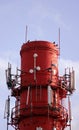 Red and white tube boiler with cables of telecommunications equipment, primarily for cellular transmission