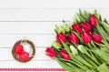 Red and white tulips and decorative Easter eggs in small nest on white table. Top view Royalty Free Stock Photo