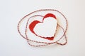 Red and white twine wound around layered paper valentine hearts