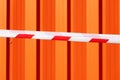red and white warning caution tape on an orange background. Danger unsafe area warning do not enter. Concept of no entry. Copy