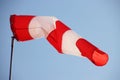 Red and white wind cone with blue sky as background Royalty Free Stock Photo