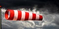 Red and White Windsock Against a Dramatic Sky with Storm Clouds - Generative Ai Royalty Free Stock Photo