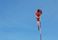 A red and white windsock hanging in tranquil weather