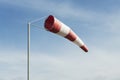 Red and white windsock wind filled blue sky background Royalty Free Stock Photo