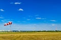 Red and white windsock wind sock on blue sky, green field and clouds background on aerodrome or airdrome. Shows wind speed and Royalty Free Stock Photo