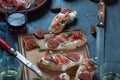 Red and white wine and bruschetta with bacon on a dinner table