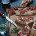 Red and white wine and bruschetta with bacon on a dinner table