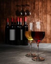 Red and white wine in clear glass, many blurred wine bottle backgrounds Place it on a cement floor with a wooden board wall. The Royalty Free Stock Photo