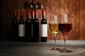 Red and white wine in clear glass, many blurred wine bottle backgrounds Place it on a cement floor with a wooden board wall. The Royalty Free Stock Photo