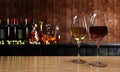 Red and white wine in clear glass, many blurred wine , whisky and brandy bottle backgrounds Place it on a wooden and mable floor Royalty Free Stock Photo