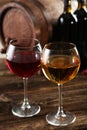Red and white wine glass with bottle and barrel on a brown wooden background Royalty Free Stock Photo