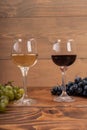 Red and white wine glasses and grape on wooden table Royalty Free Stock Photo