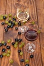 Red and white wine glasses and grape on wooden table Royalty Free Stock Photo