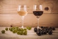 Red and white wine glasses and grape on wooden table Royalty Free Stock Photo