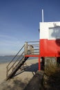 Red and white wooden lifeguard cabin with a stair on an empty sandy beach in Pirita. Empty beach with no people on a Royalty Free Stock Photo