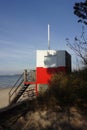 Red and white wooden lifeguard cabin with a stair on an empty sandy beach in Pirita. Empty beach with no people on a Royalty Free Stock Photo