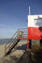 Red and white wooden lifeguard cabin with a stair on an empty sandy beach in Pirita. Empty beach with no people on a Royalty Free Stock Photo