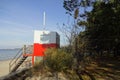 Red and white wooden lifeguard cabin with a stair on an empty sandy beach in Pirita. Empty beach with no people on a Royalty Free Stock Photo