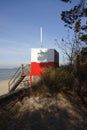 Red and white wooden lifeguard cabin with a stair on an empty sandy beach in Pirita. Empty beach with no people on a Royalty Free Stock Photo