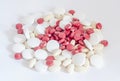 Red, white and yellow drugs pills, powder, bunch, medical, homeopathic, white background, close up.