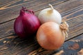 Red, white and yellow onions on wooden background Royalty Free Stock Photo