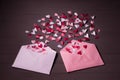 Red, whited and pink paper hearts  in open pink and white postal envelopes on grey wooden background. Valentine`s day gift Royalty Free Stock Photo