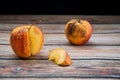 Red wilted rotten apple on a table. Bacteria infected rotten fruit