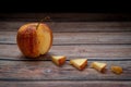 Red wilted rotten apple on a table. Bacteria infected rotten fruit