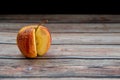 Red wilted rotten apple on a table. Bacteria infected rotten fruit