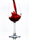 Red wine being poured into a glass against a white background. Royalty Free Stock Photo