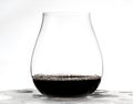 red wine being poured into round stemless glass with white background Royalty Free Stock Photo