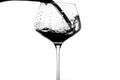 red wine being poured into tall stemmed glass with white background Royalty Free Stock Photo