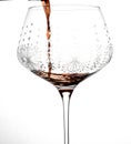 red wine being poured into tall stemmed glass with white background Royalty Free Stock Photo