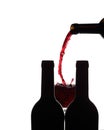 Red wine being poured between two bottles of wine