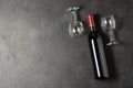 Red wine in a bottle. Black concrete background. Flat lay. Copy space