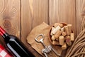 Red wine bottle, bowl with corks and corkscrew. View from above